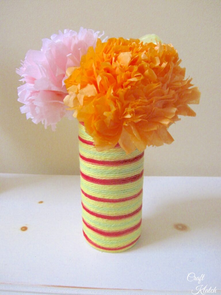 Red and yellow string wrapped vase with orange and pink tissue paper flowers