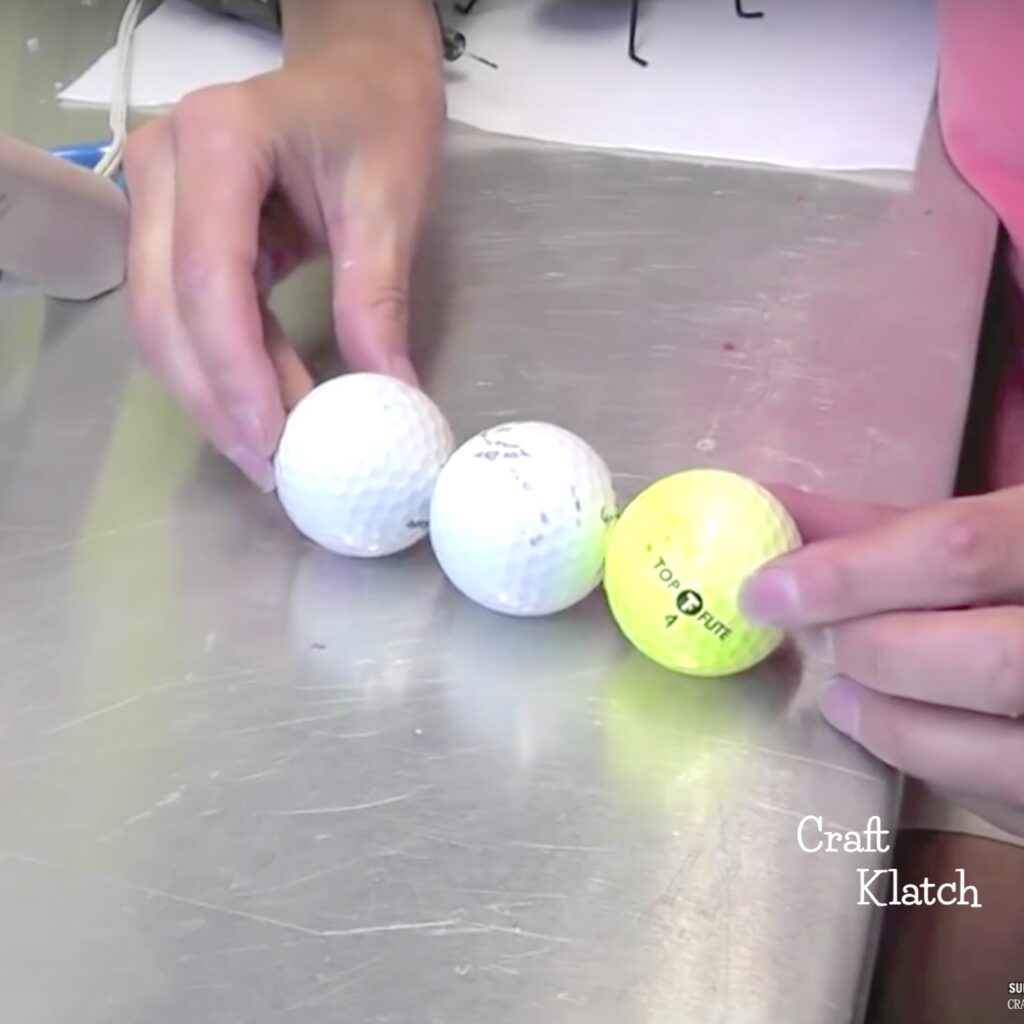 Hands holding together three golf balls for giant garden ants craft - using recycled materials for the project