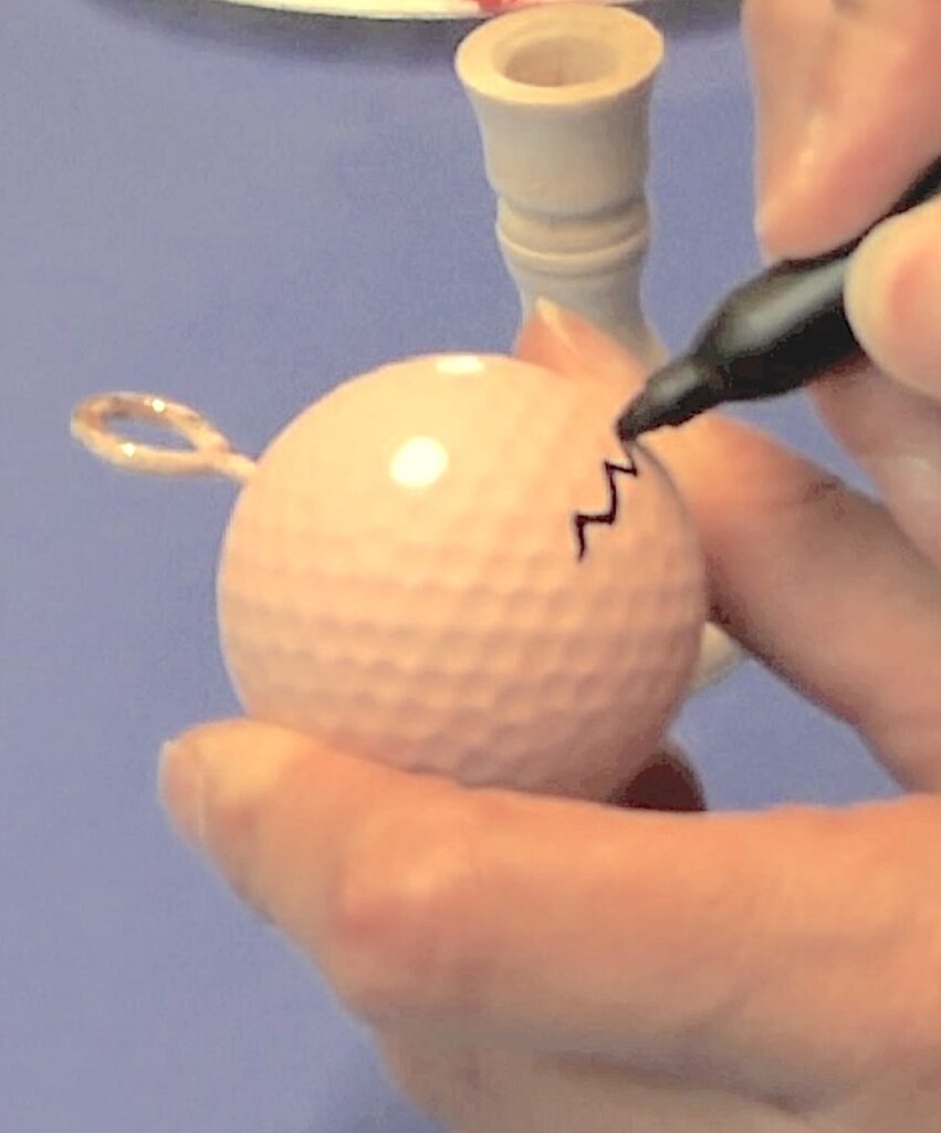 Draw mouth onto flesh golf ball with a black permanent marker