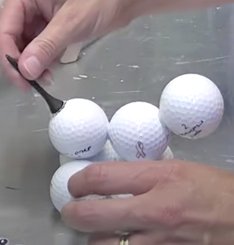 Glue black golf tee onto golf balls for the dog tail