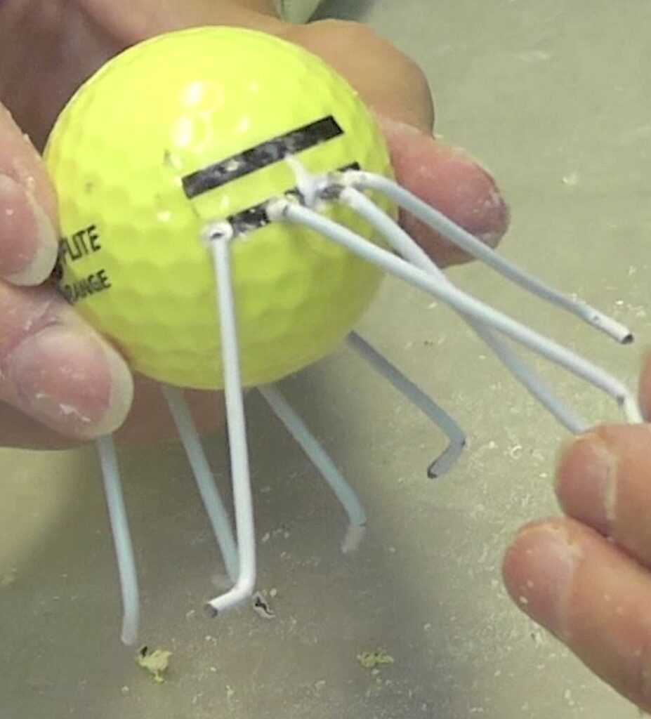 Insert wire legs into the golf ball holes