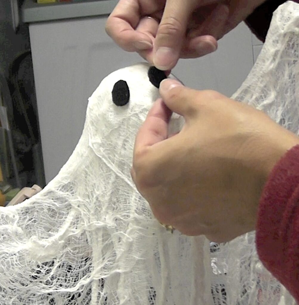 Glue black felt ovals onto the cheesecloth ghost for eyes