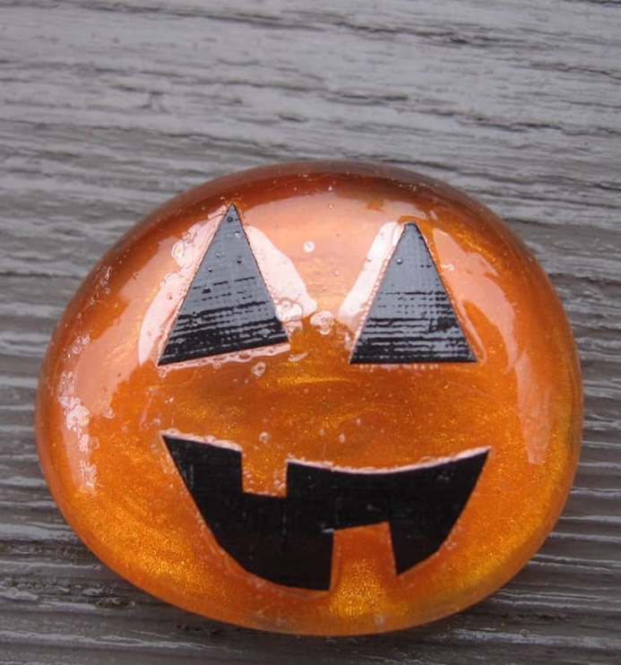 Original pumpkin with black features on the top_front of the stone