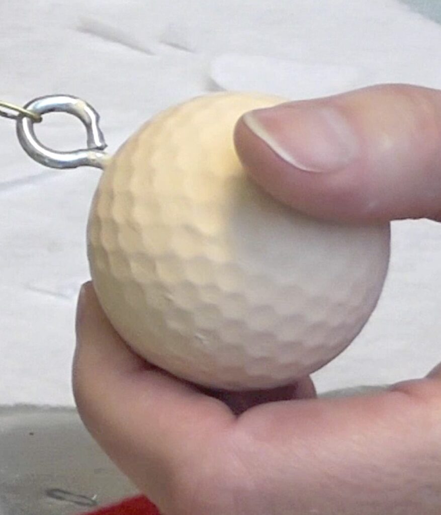 Paint golf ball with flesh colored acrylic paint and add an eye screw