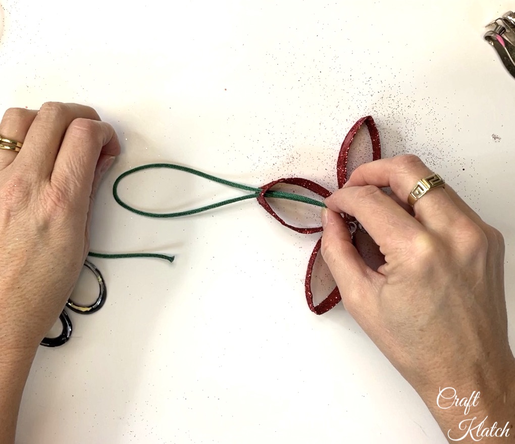 Adding ribbon to toilet paper flower ornament