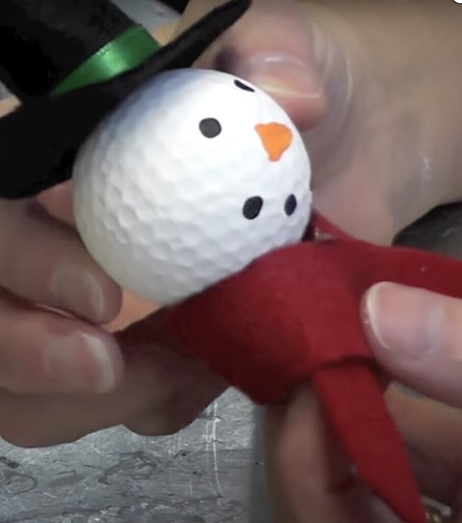 Glue on the scarf to the bottom of the snowman