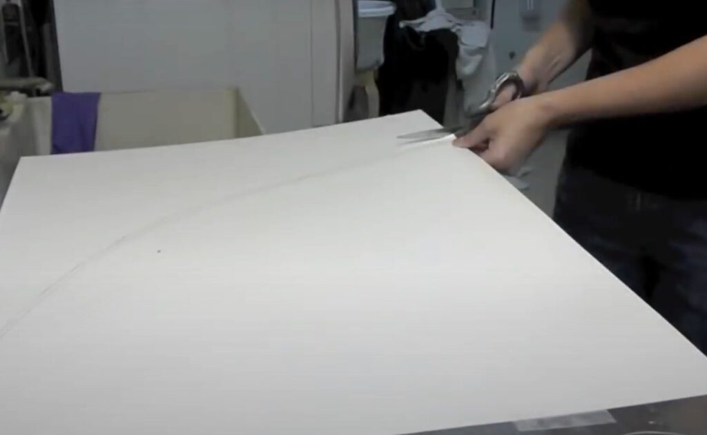 Cutting out poster board with a scissor