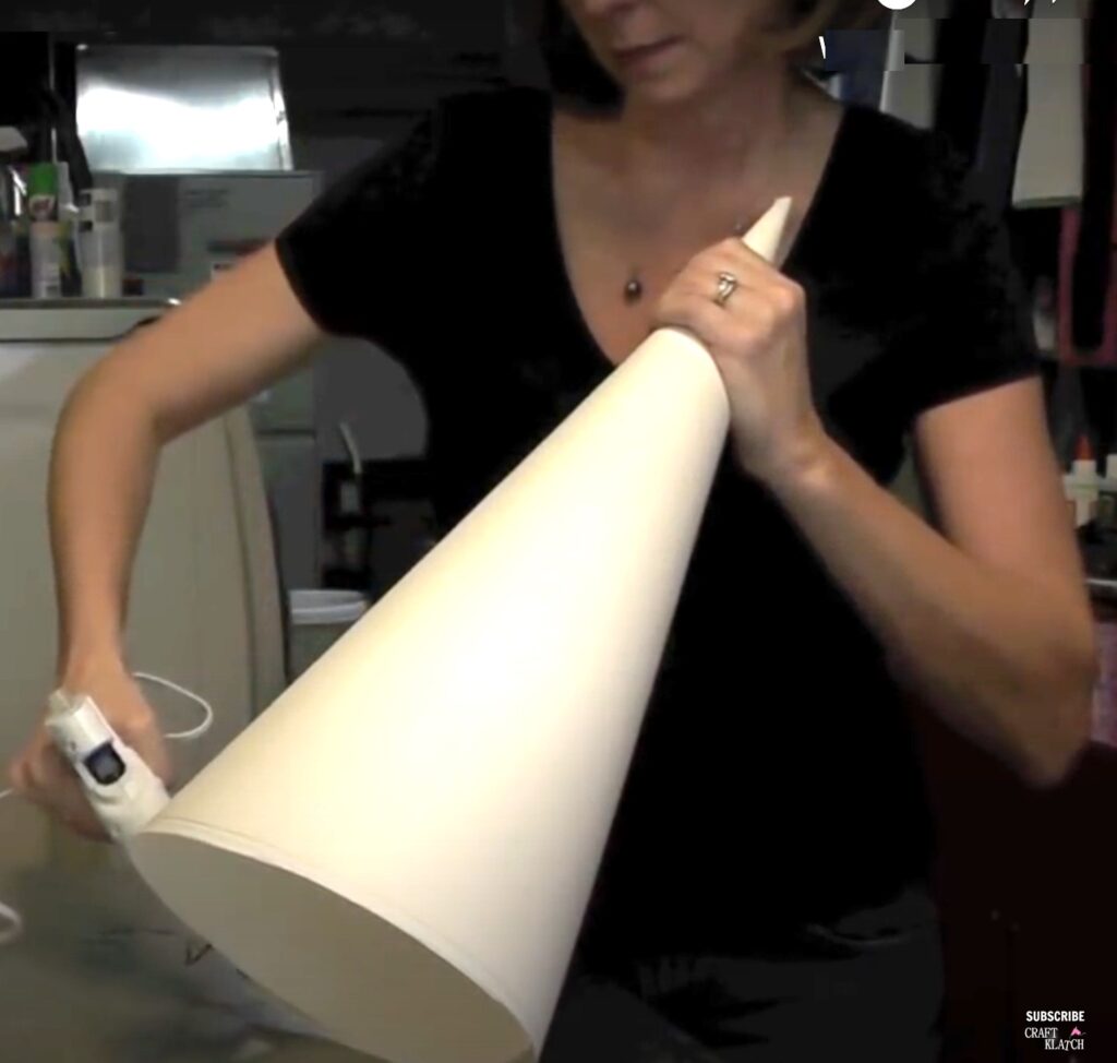 Using hot glue to glue the cone out of paper copy