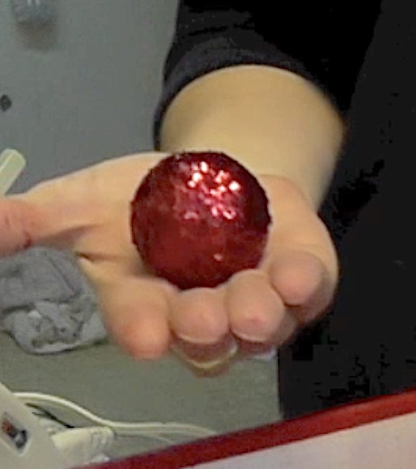 Golf ball covered in red glitter for Christmas pine cone tree