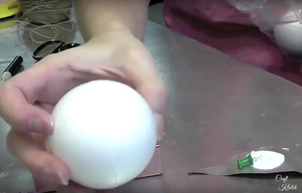  Holding styrofoam ball and pushpin dipped in glue
