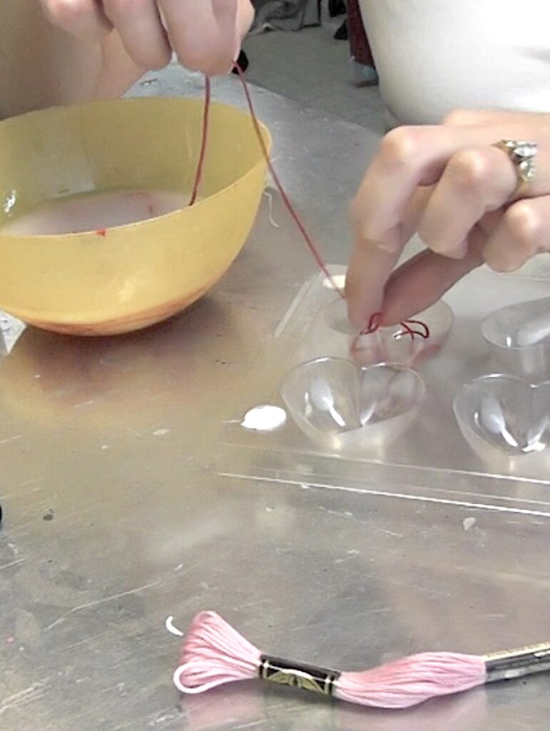 Feed the starchy embroidery floss into the heart mold
