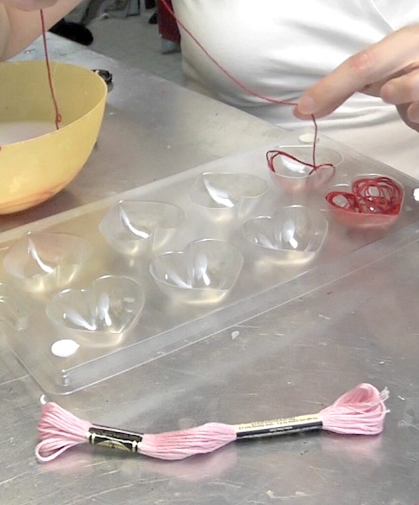 Fill plastic heart mold with red embroidery floss