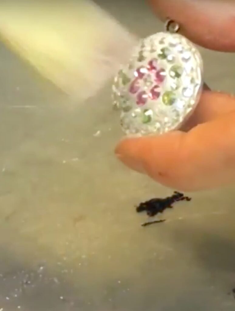 After curing brushing off excess pigment powder from jewelry piece