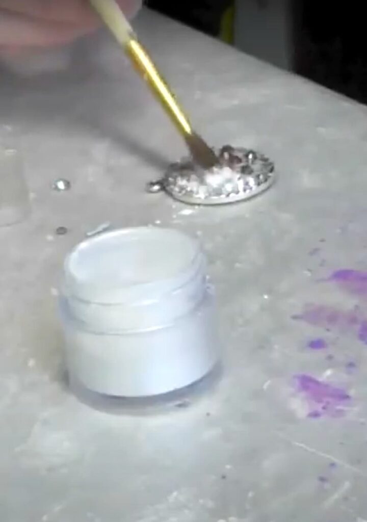 Brushing pigment poweder onto the epoxy clay jewelry pendant