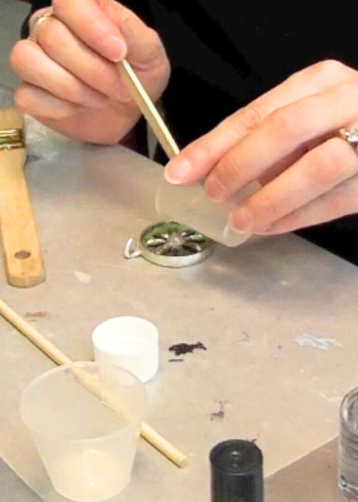 Pouring resin into the metal jewelry pendant