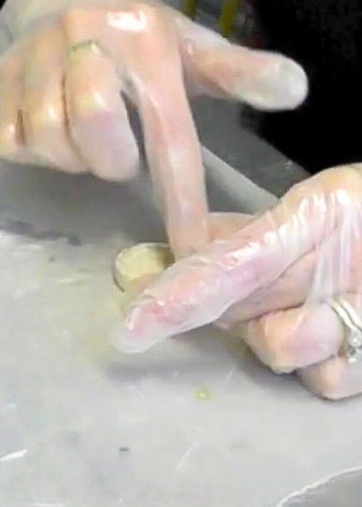 Pressing epoxy clay into a bezel while showing hwo to make metal jewelry