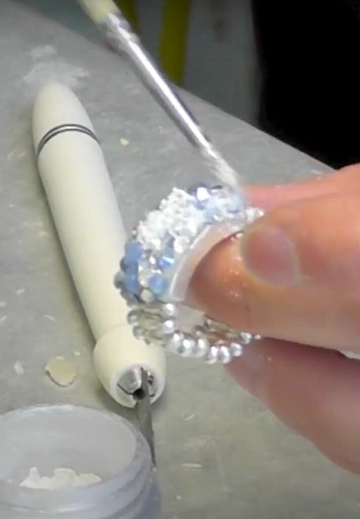 Brushing pigment powder onto the ring with epoxy clay