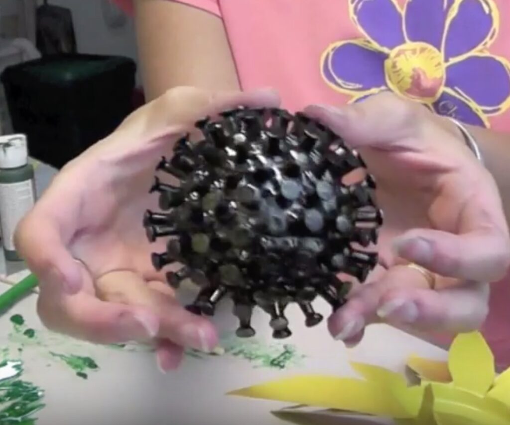 Half styrofoam ball covered in pushpins painted black