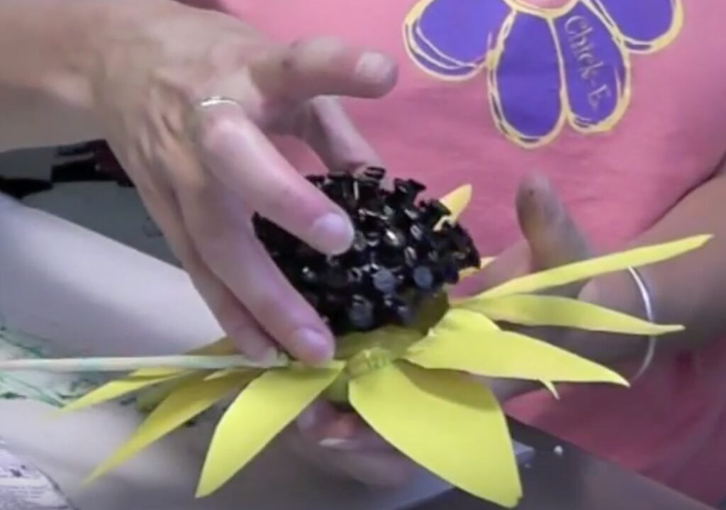 Add the black styrofoam ball with pushpins to the center of the two flowers