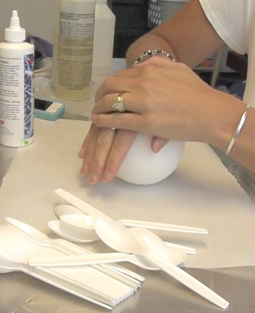 Hands pressing down on white styrofoam ball