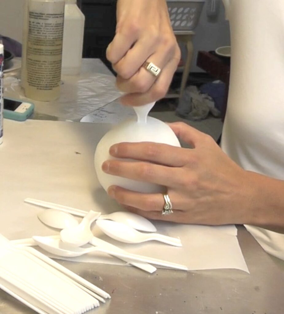 Press broken white spoon into styrofoam ball