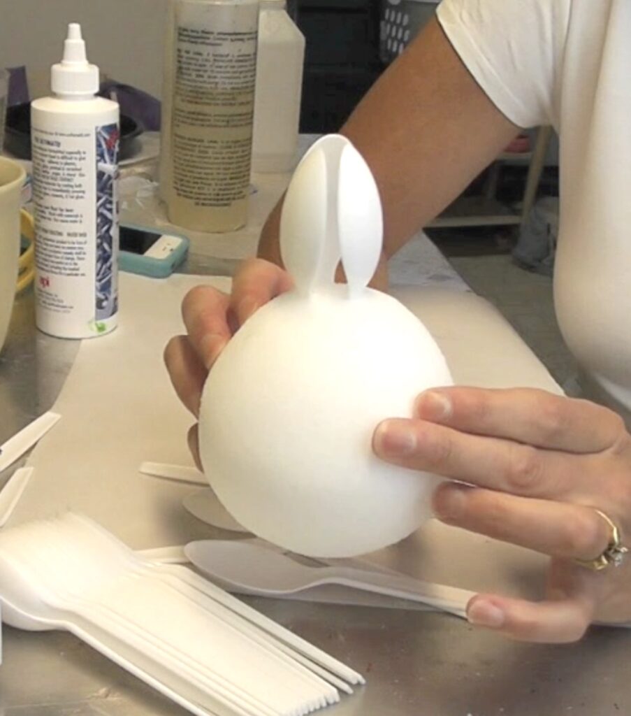 Three broken spoons inserted into the top of the styrofoam ball to form artichoke leaves