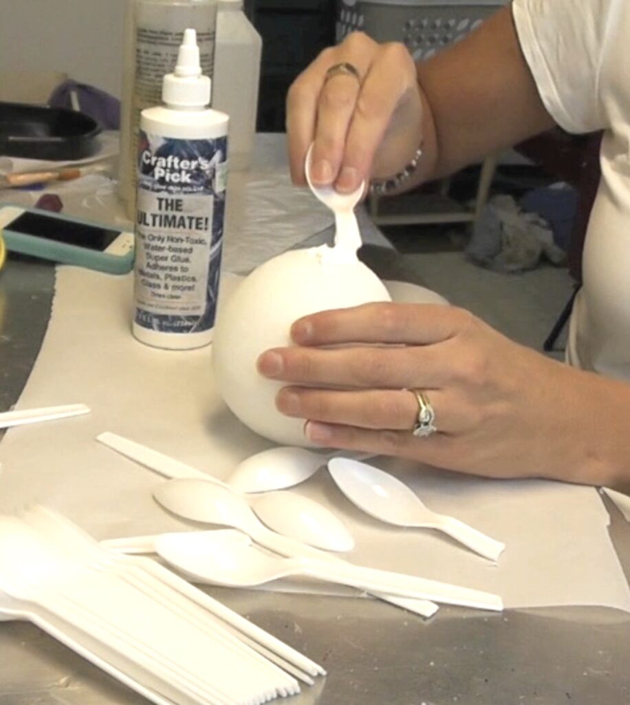 Move the glue around the surface one section at a time with the plastic spoon