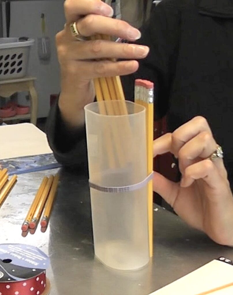 Add pencils under the rubberband for the vase
