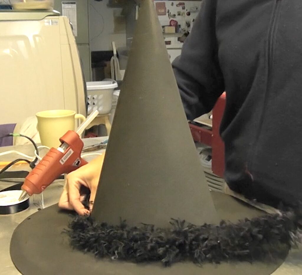 Glue on fuzzy black trim around the base of the cone
