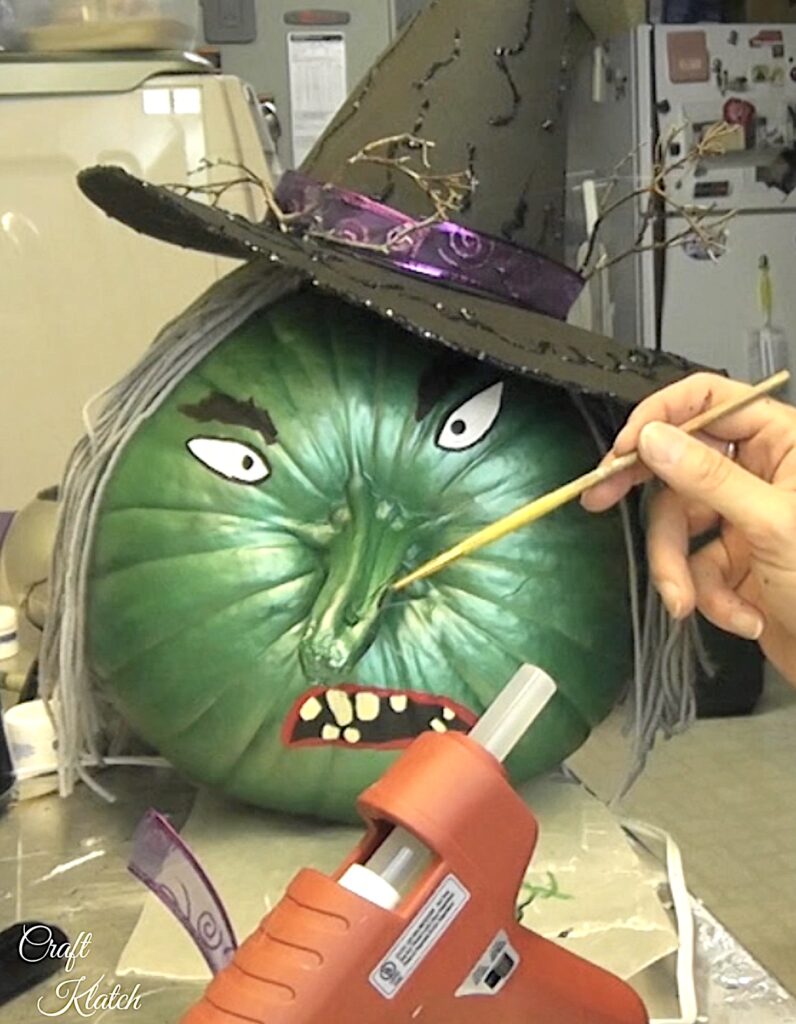 Paint the hairs coming out of the painted pumpkin witch wart on her nose