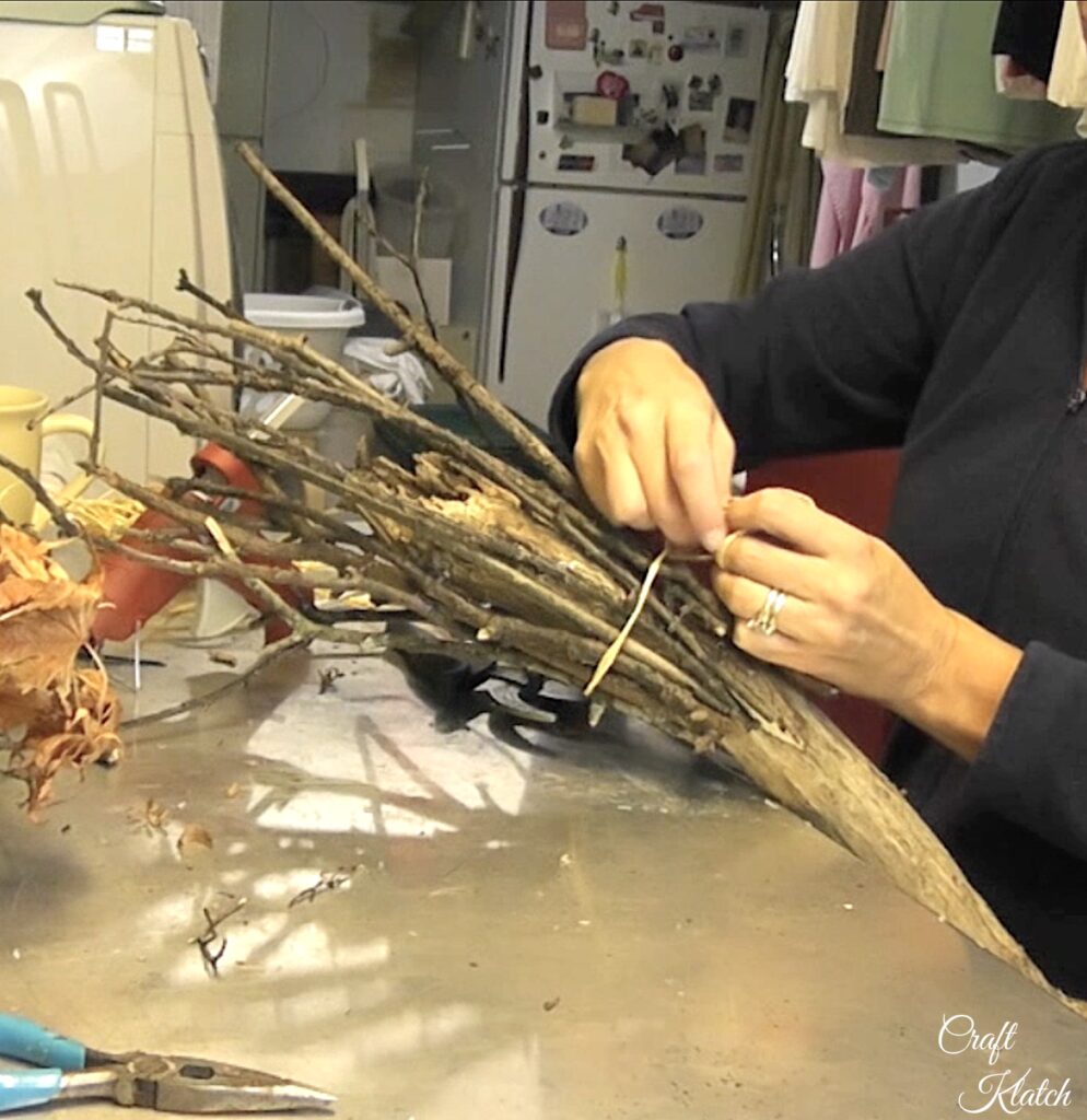 Tie twine around the twigs for the witch's broom