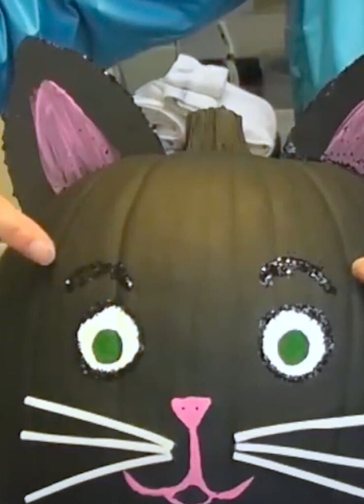 Glittered eyebrows on the black cat pumpkin painted for Halloween