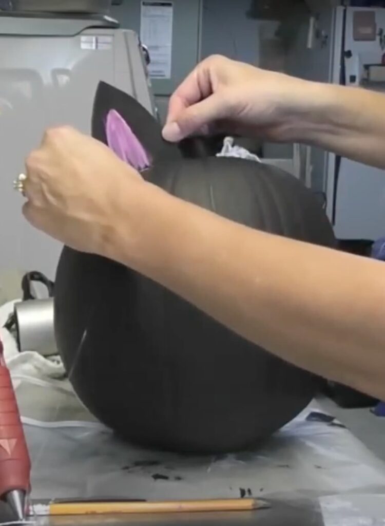 Gluing ears on the black cat pumpkin