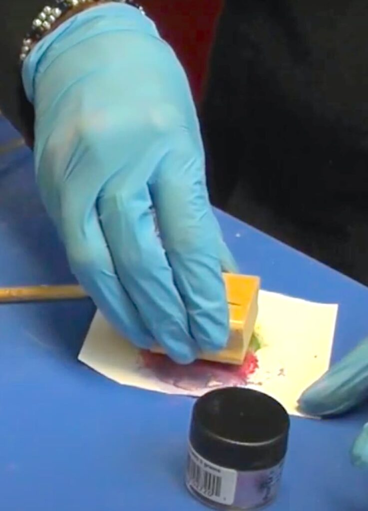 Pressing the hummingbird rubber stamp into the back of the epoxy clay