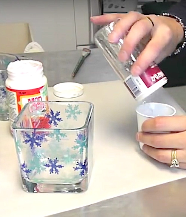 Pour silver glitter into cup to make snowflake votives