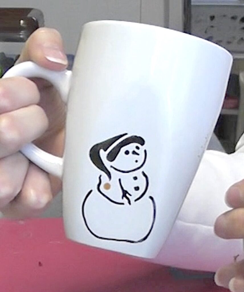 White hot choclate mug with black outlines snowman on the side