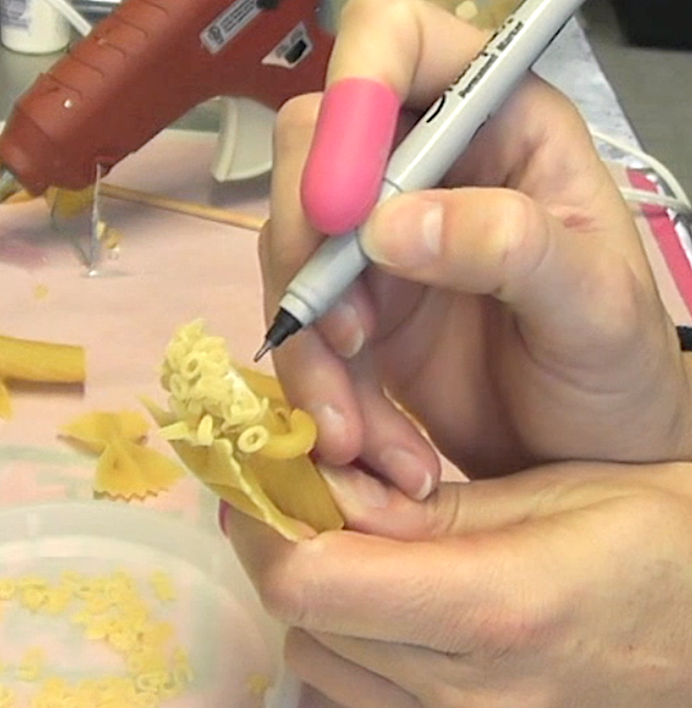 With permanent marker, draw a face on the pasta angel