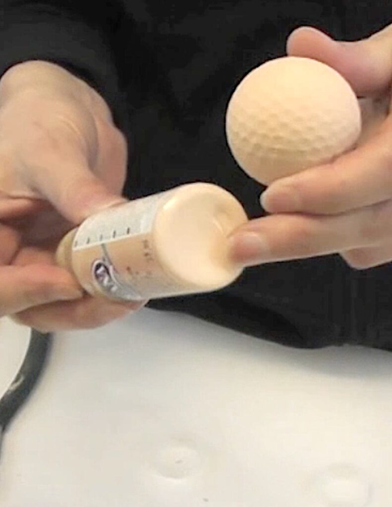 Paint golf ball with flesh colored paint