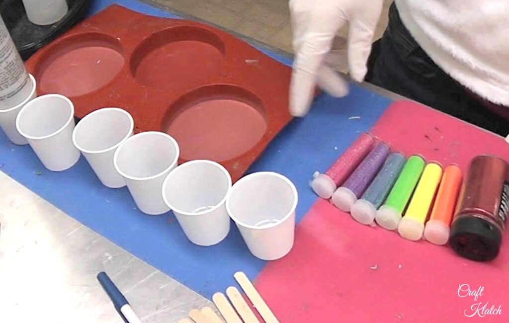 Cups and glitter lined up on craft table