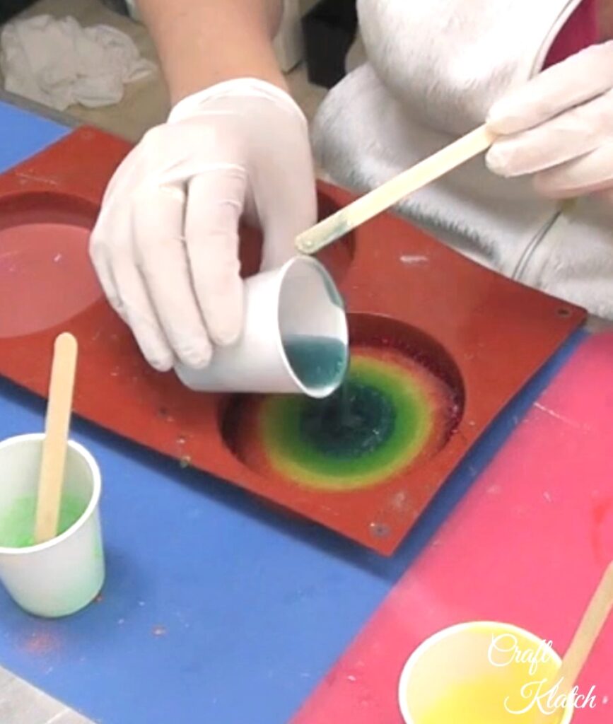 Pour rainbow colored resin into the coaster mold