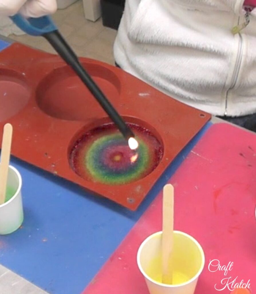 Use lighter to pop bubbles in resin coaster