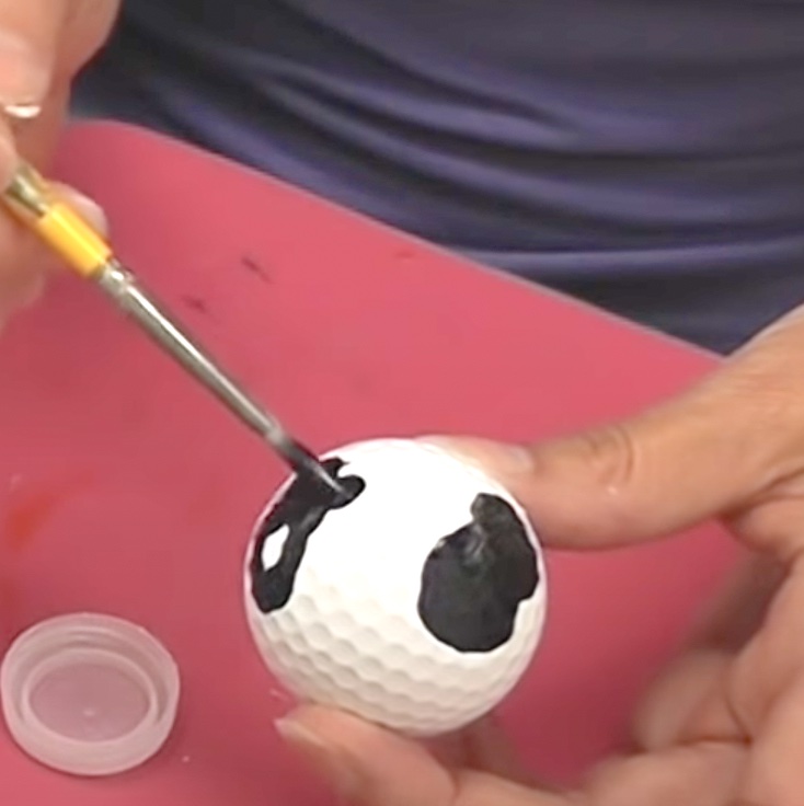 Paint cow spots onto the white golf ball