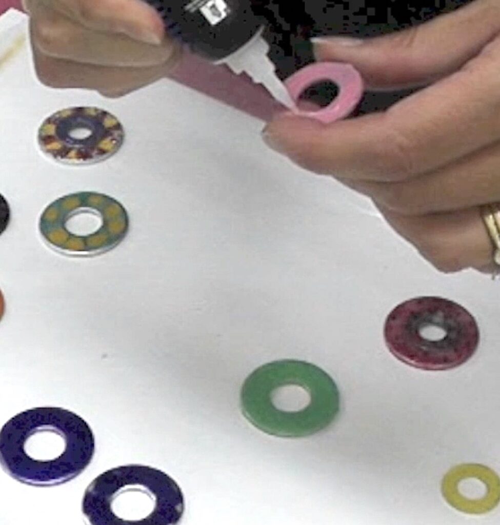 Add glue to washers to create a stacked charm