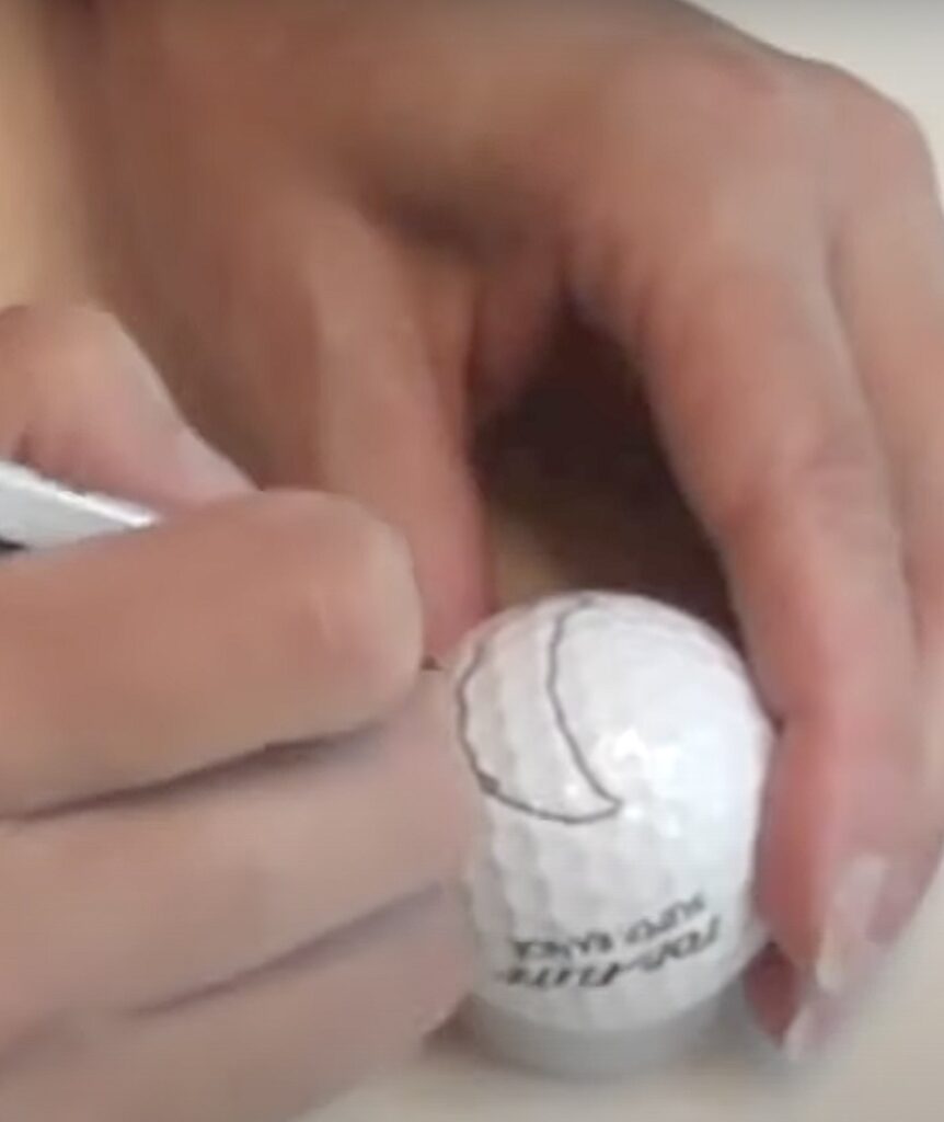 Draw shark faces on golf balls