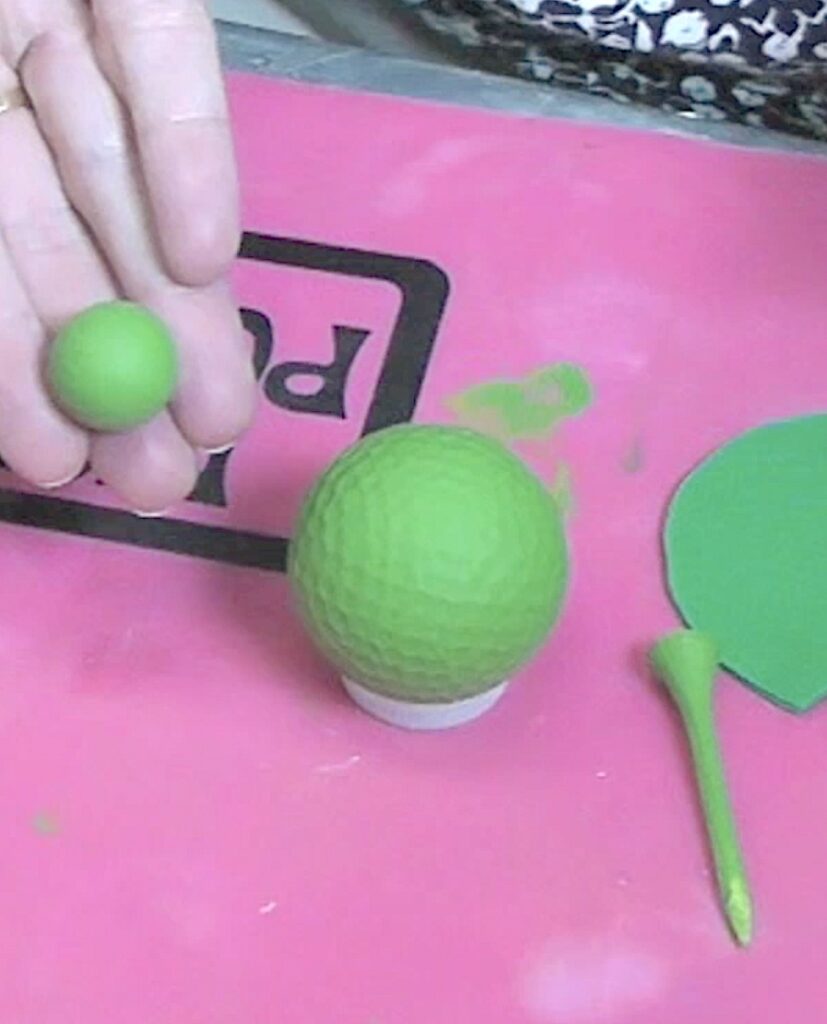 Golf ball, golf tees and wood bead painted green