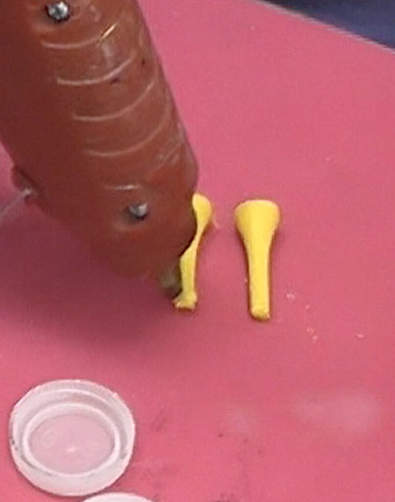 Add hot glue to the yellow golf tees