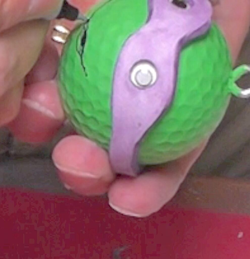 Use permanent marker to draw mouth on green golf ball