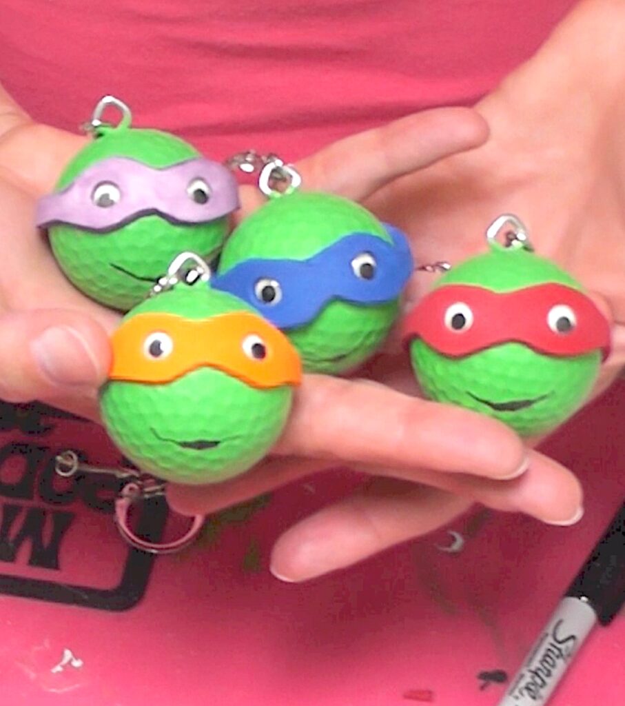 Holding four Teenage mutant ninja turtles keychains