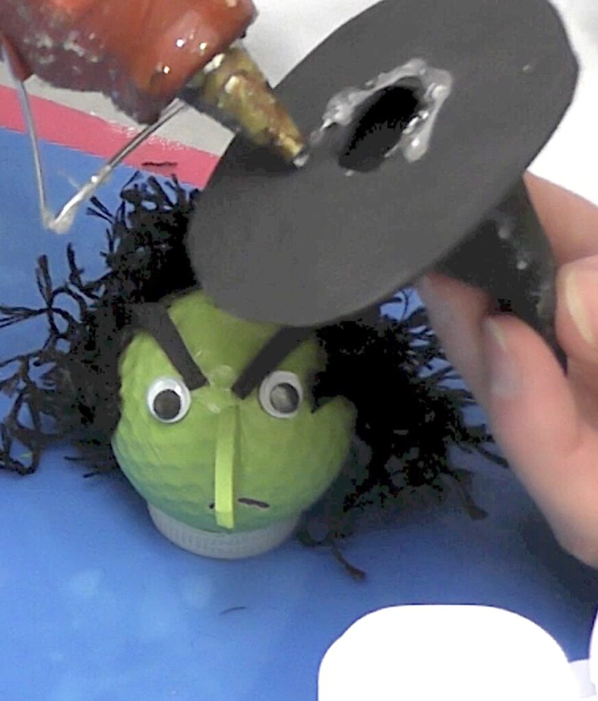 Glue on witch hat to the golf ball witch head
