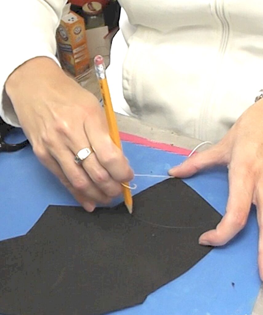 Use pencil and string to draw an arch on black foam